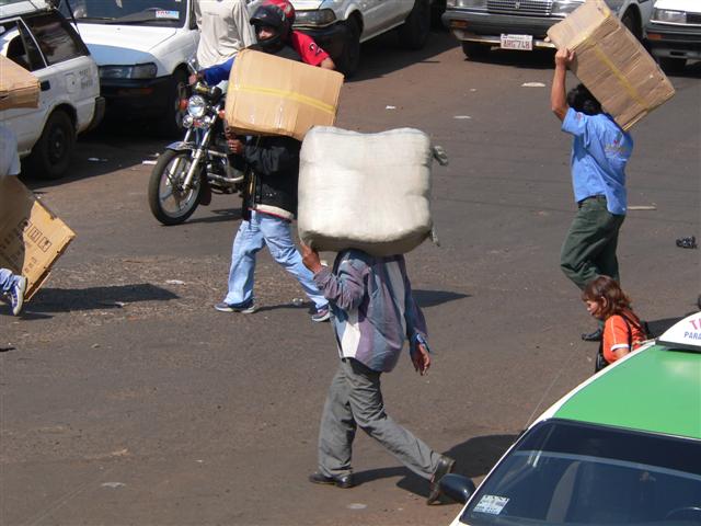 People carrying boxes on shoulders